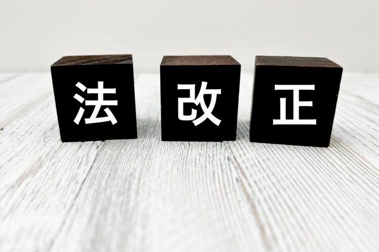 白い木目の机の上に、黒いブロックが3つ並び、それぞれに「法」「改」「正」と白い文字が書かれている。