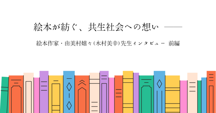 カラフルな本が横一列に並ぶイラストを背景に、中央にタイトル「絵本が紡ぐ、共生社会への想い ――」と書かれている。 その下に「絵本作家・由美村嬉々（木村美幸）先生インタビュー 前編」と記され、温かみのある絵本特集のアイキャッチ画像となっている。