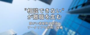 高層ビル群を下から見上げた写真を背景に、中央に黒文字で「“相談できない”が離職を生む　障がい者雇用の現状とワークリアの挑戦　後編」と書かれたタイトル画像。青空とビルのコントラストが印象的なデザイン。