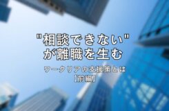 高層ビル群を下から見上げた写真を背景に、中央に黒文字で「“相談できない”が離職を生む ワークリアの支援策とは【前編】」と書かれたタイトル画像。青空とビルのコントラストが印象的なデザイン。