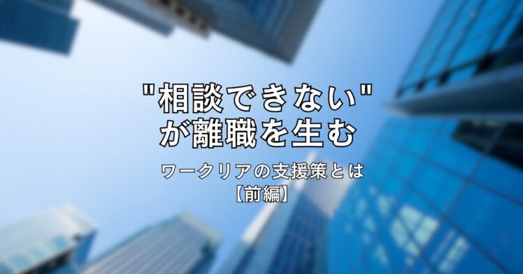 高層ビル群を下から見上げた写真を背景に、中央に黒文字で「“相談できない”が離職を生む　ワークリアの支援策とは【前編】」と書かれたタイトル画像。青空とビルのコントラストが印象的なデザイン。