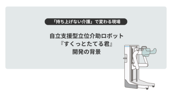 淡いグレーの背景の中央に、黒い文字で大きく「自立支援型立位介助ロボット『すくっとたてる君』開発の背景」と書かれている。 その上には黒い帯に白文字で「持ち上げない介護」で変わる現場、という見出しがある。 右側には白と水色を基調とした介助ロボットのイラストが描かれ、立ち上がりをサポートする形状が示されている。 全体として、介護の負担軽減や自立支援をテーマにしたスライドのタイトル画像。