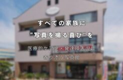 3階建ての建物を背景に、中央に白い文字でキャッチコピーが書かれている。 上部の文字は「すべての家族に “写真を撮る喜び”を」。 その下には「医療的ケア児・発達障害児に寄り添う写真館」と書かれている。 建物の外観は淡いベージュ色で、正面に大きな窓と看板があり、晴れた青空の下で撮影されている。 障害や医療ケアが必要な子どもたちと家族に、写真撮影の楽しさを届ける想いを表現したメインビジュアル。