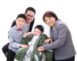 紋付き袴を着た男の子を囲んで、家族がやさしく寄り添いながら笑顔を見せている。 温かな絆と、共に過ごす時間の大切さが伝わる家族写真。